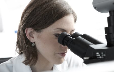 Une chercheuse regardant dans un microscope