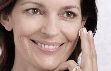 Femme appliquant de la crème sur son visage