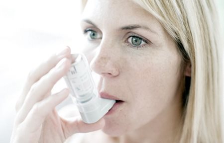 Femme utilisant un inhalateur.