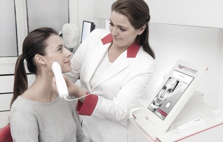Dermatologue utilisant le Skin Code Reader sur le visage d'une femme