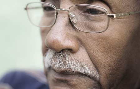 Homme âgé à la peau foncée dont les sillons naso-labiaux sont visibles