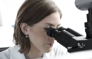 Une chercheuse regardant dans un microscope