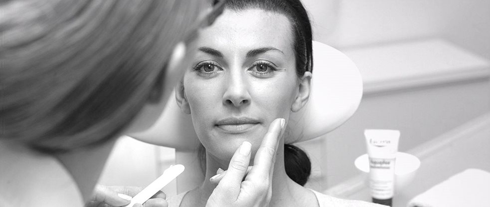 Le visage d’une femme est traité avec un produit Eucerin