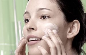 Femme utilisant le Gel Nettoyant sur les joues