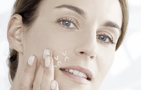 Femme appliquant le concentré entre les yeux