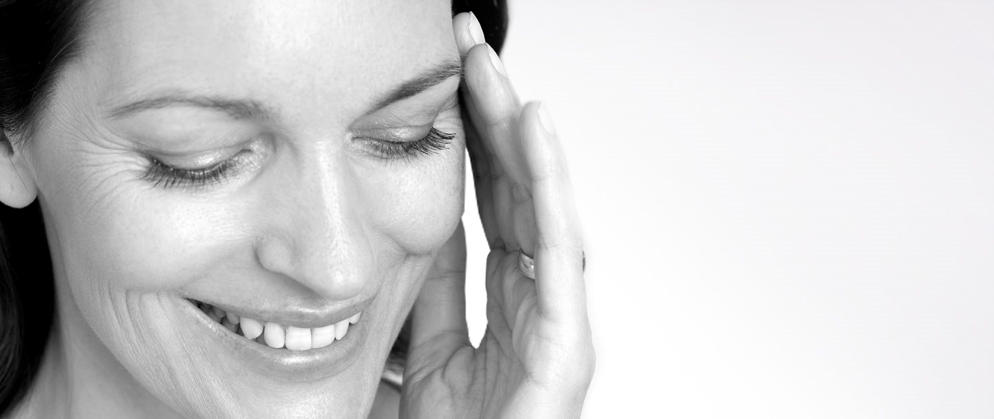 Femme se touchant le visage avec la main gauche.