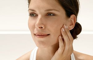 Femme s'appliquant un écran solaire