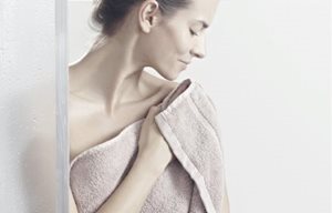 Femme qui se tapote la peau après la douche pour la sécher.
