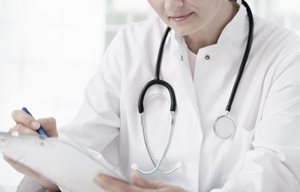 Docteur avec un stéthoscope autour du cou, notant quelque chose.