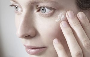 Femme se touchant le visage de la main.