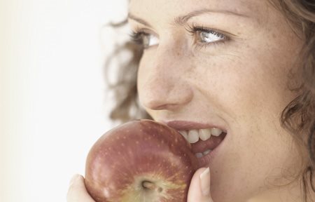 Femme mangeant une pomme rouge