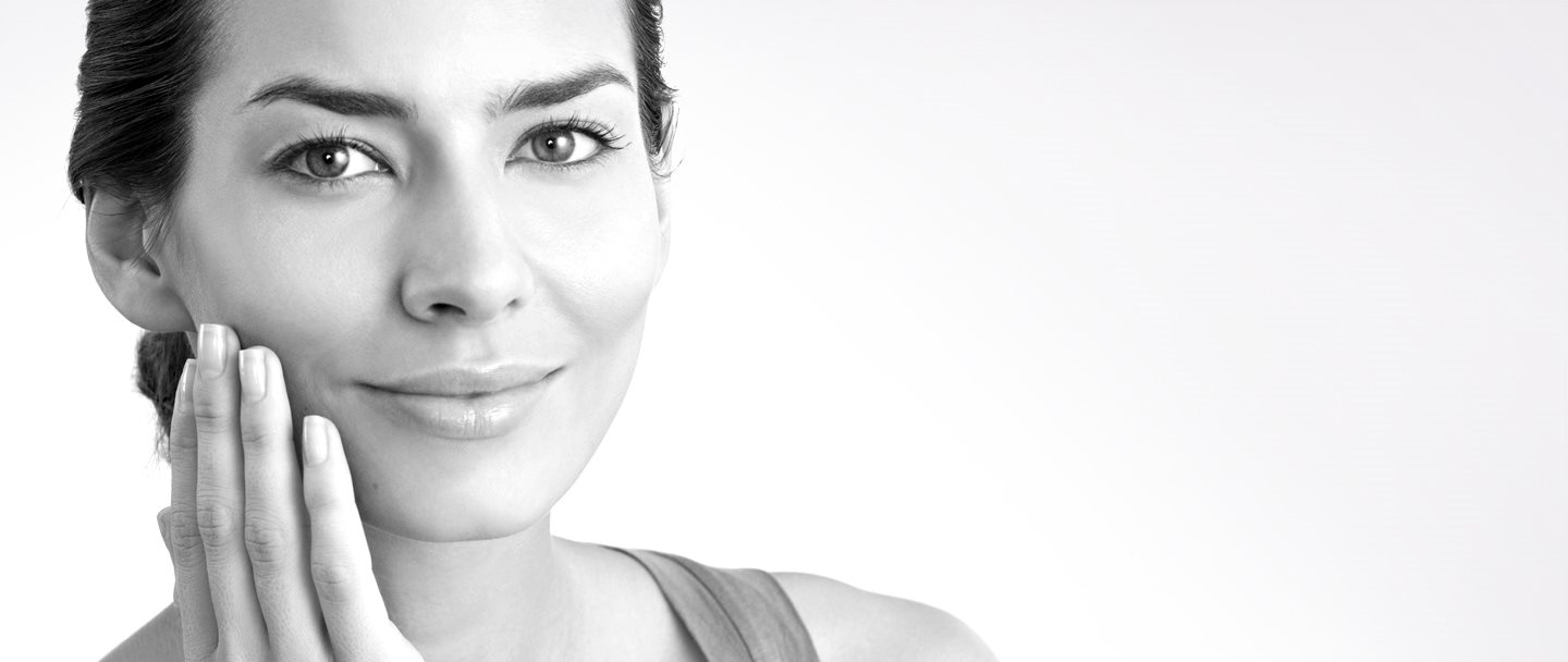 Femme d'âge moyen qui se touche la joue droite avec la main