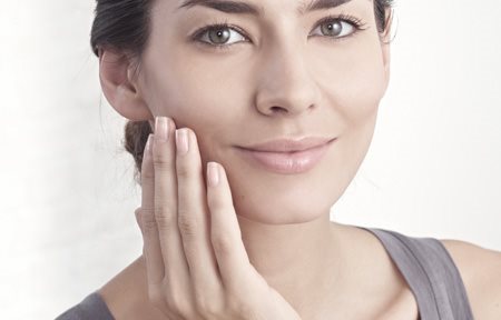 Femme appliquant de la crème sur son visage
