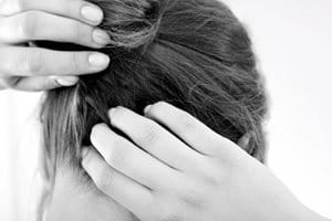 Femme grattant son cuir chevelu sujet aux démangeaisons