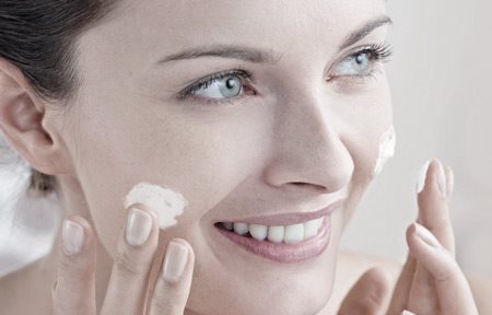 Femme s'appliquant de la crème sur le visage